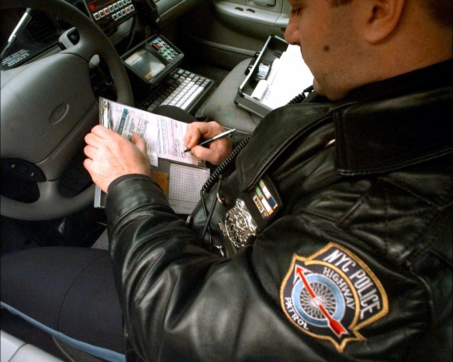 An image of a police officer handing out a speeding ticket.