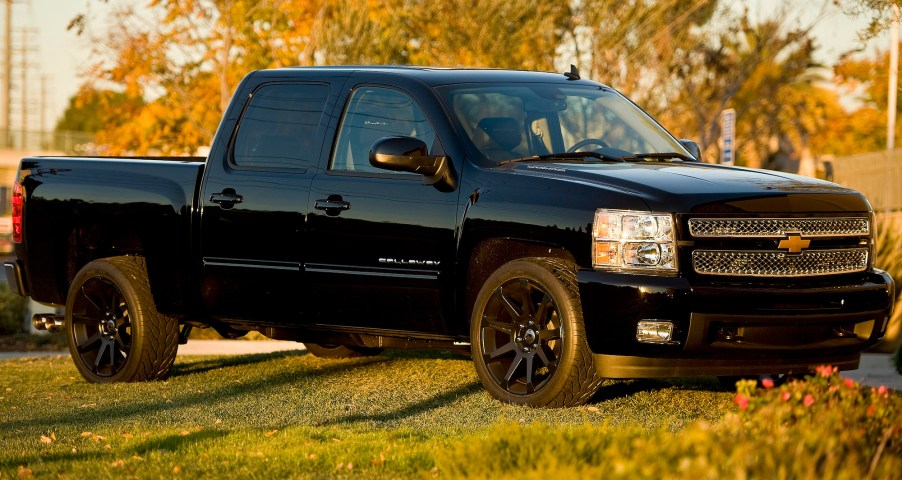 A black 2013 Chevy Silverado is parked on grass in Santa Ana, California.