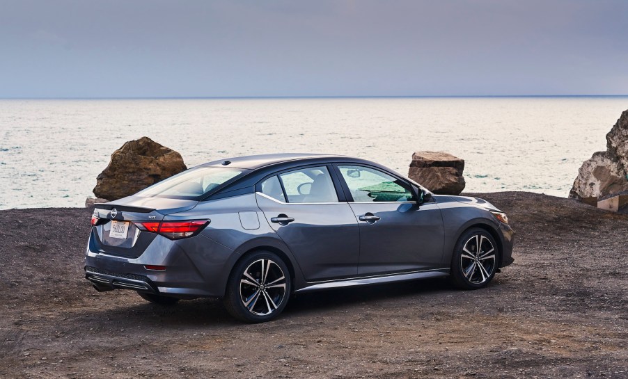 A 2021 Nissan Sentra in Gun Metallic is parked overlooking an ocean.