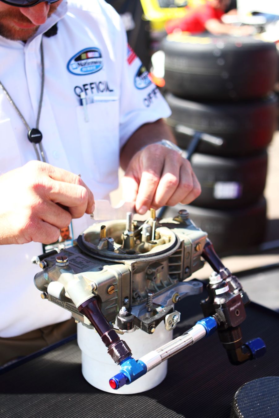 A race official inspects a NASCAR carburetor