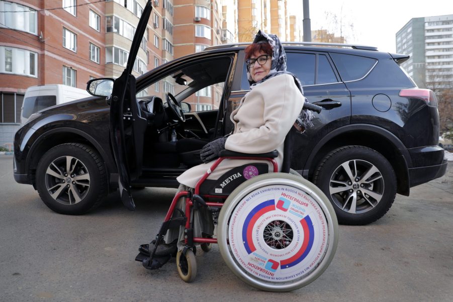 Working pensioner Olga Abukova, 62, in a wheelchair near her car