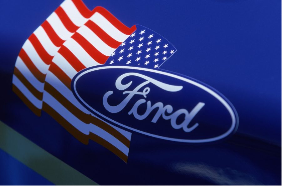 A Ford logo seen next to an American flag