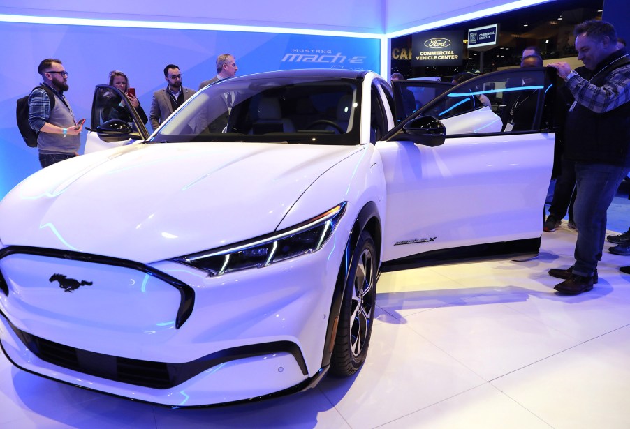 Attendees examine the Ford Mustang Mach-E all electric vehicle at the Chicago Auto Show at McCormick Place