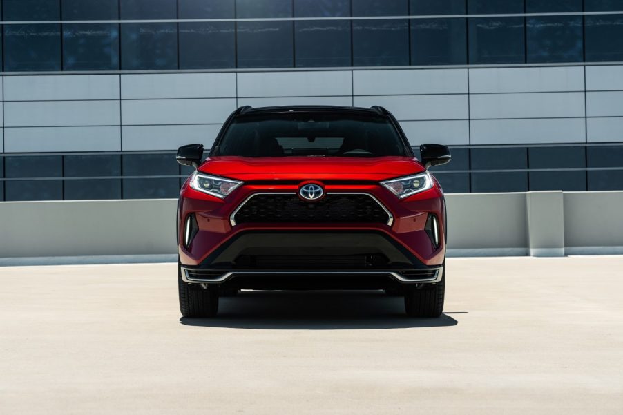 A red 2021 Toyota RAV4 Prime parked on the top of a parking deck.