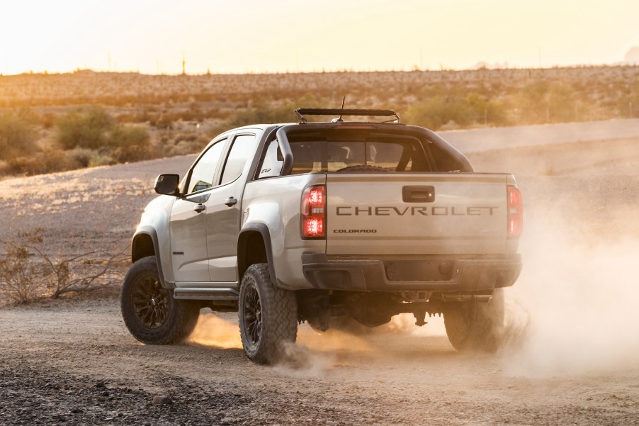 A silver 2021 Chevrolet Colorado ZR2 kicks up some dust on a dirt road