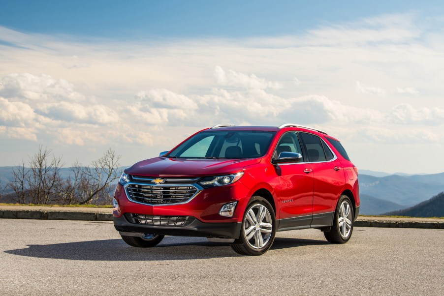 A red 2021 Chevy Equinox parked on pavement with a blue sky in the background