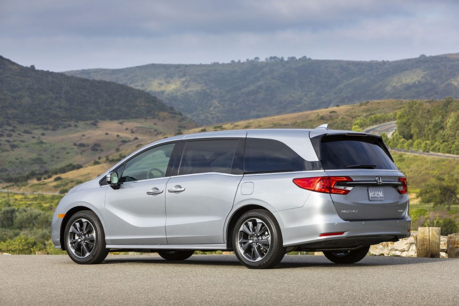 A silver 2021 Honda Odyssey parked on a road in front of mountains