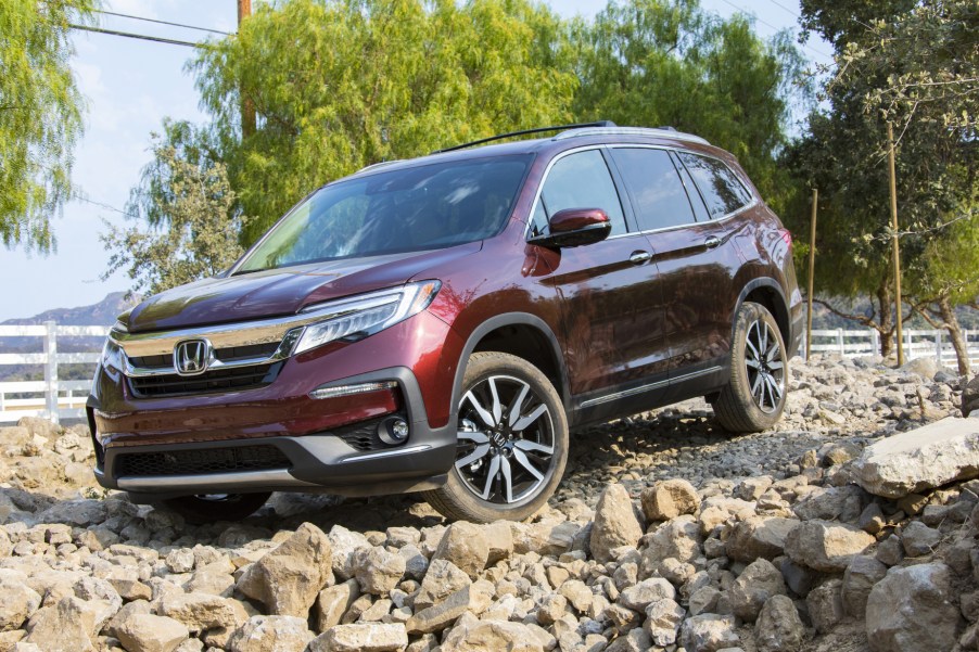 A dark red 2021 Honda Pilot parked on rocky terrain