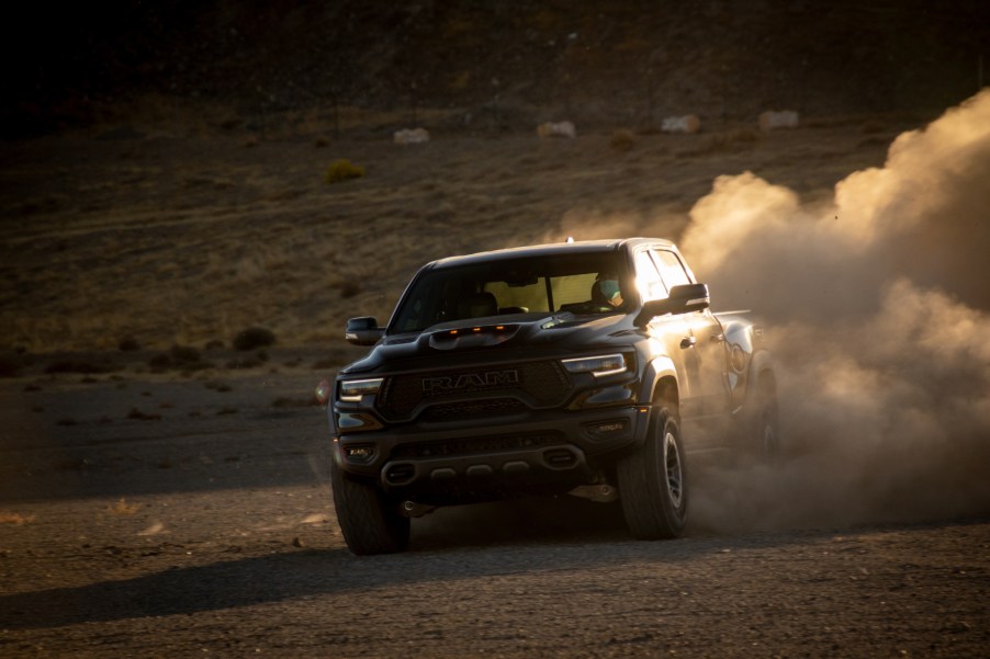 A black 2021 Ram 1500 TRX driving off-road with dirt kicking up