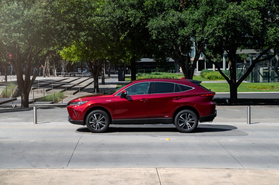 A dark-red 2021 Toyota Venza LE stopped on a city street