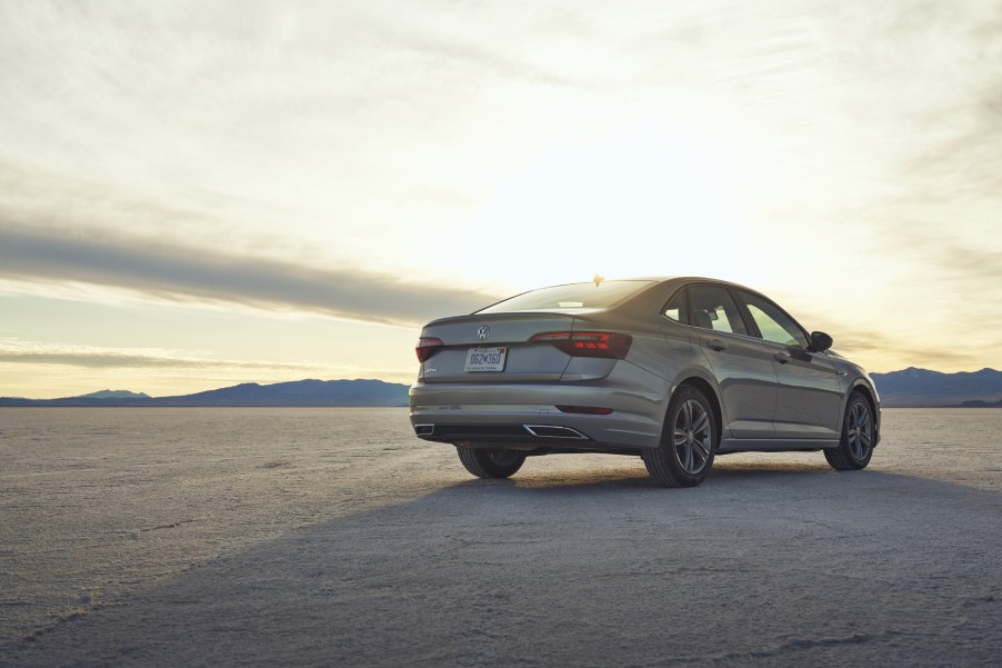 A silver 2021 Volkswagen Jetta parked with the sun in the background