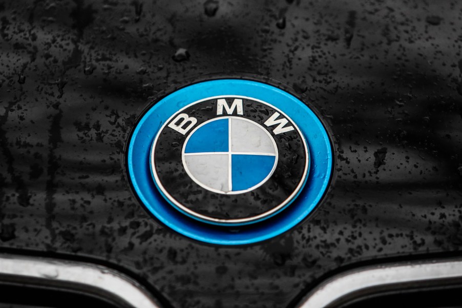 Raindrops are seen on a silver and blue BMW logo of the hood of a black car on January 5, 2020.