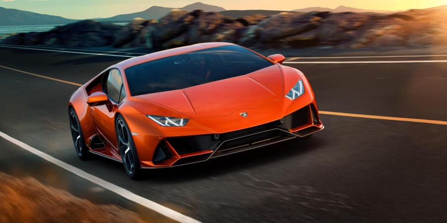 An orange Lamborghini Huracán EVO travels on a paved mountain road