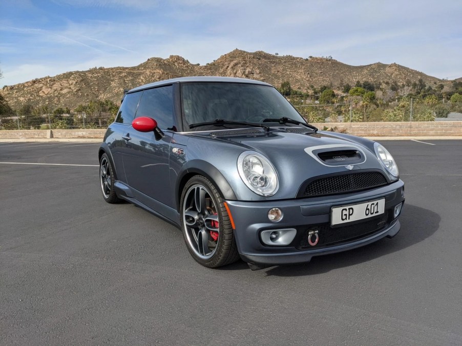 The front 3/4 view of a gray-with-red-mirrors 2006 Mini Cooper S John Cooper Works GP in a desert parking lot