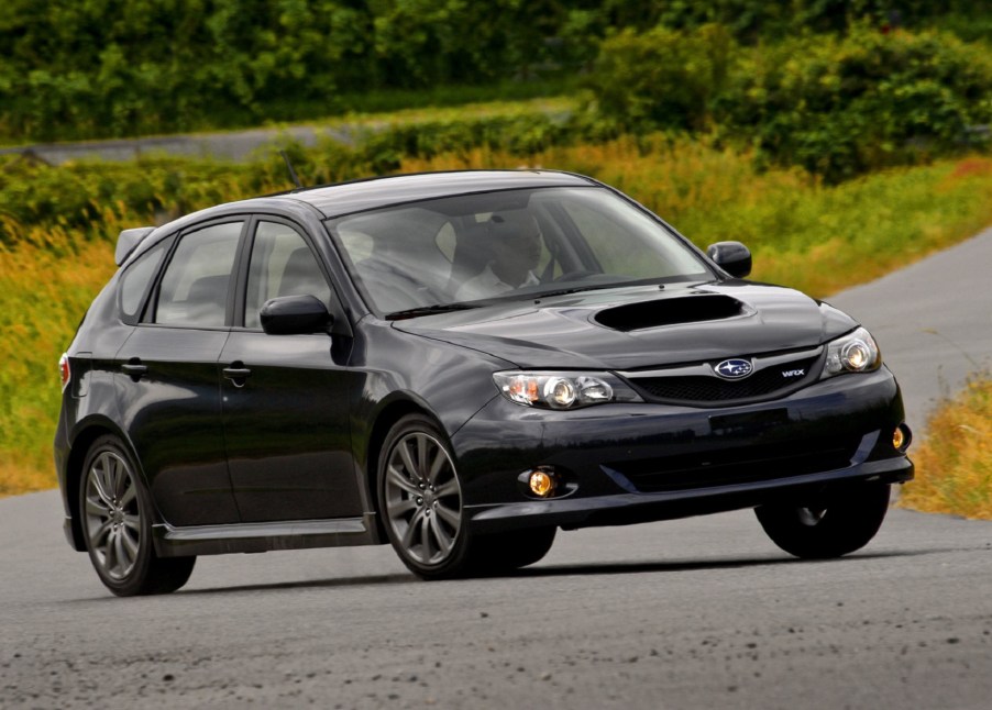 A black 2009 Subaru Impreza WRX hatch on a backcountry road