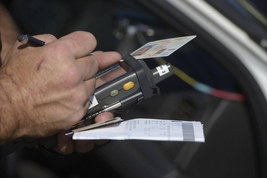 A police officer issues a speeding citation using a e-citation machine in 2020