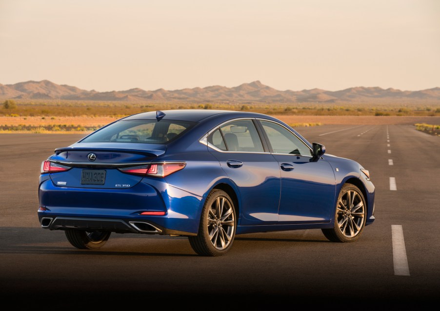 A royal-blue 2021 Lexus ES parked on a rural road with mountains in the distance