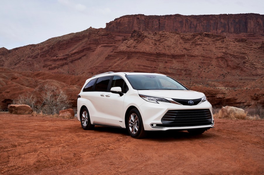 A white 2021 Toyota Sienna Limited minivan parked on red dirt in front of a butte