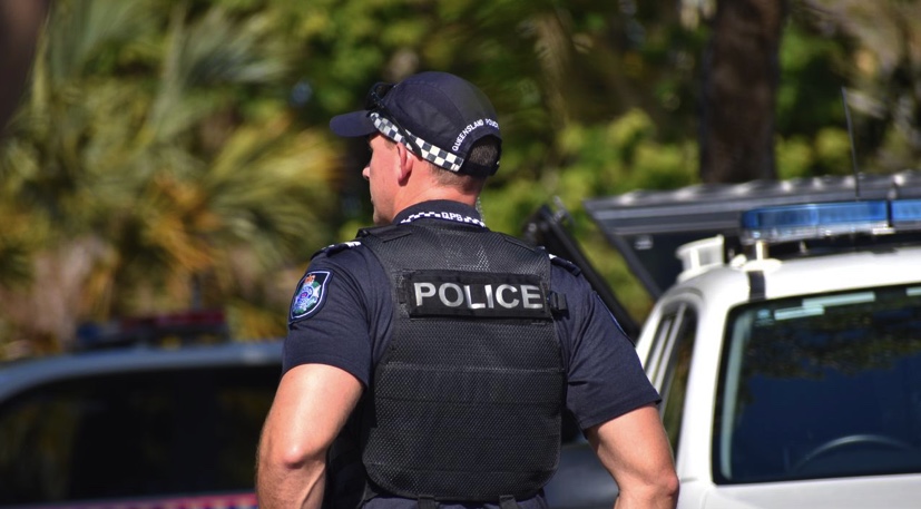 A police officer standing outside in uniform.