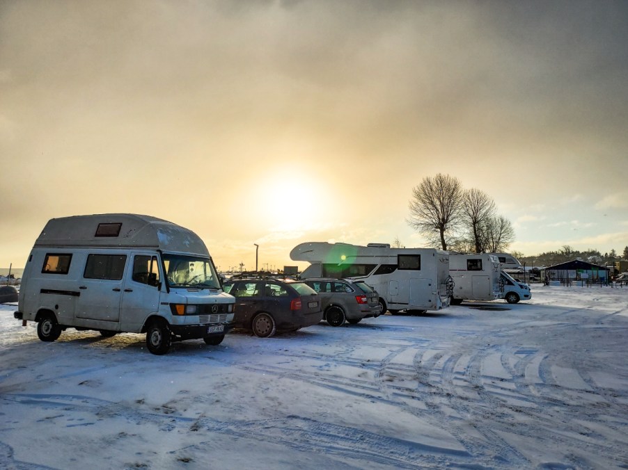 Camper vans and motorhomes parked in a snowy parking lot