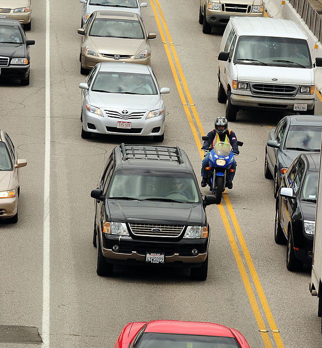 motorcyclist lane splitting in traffic