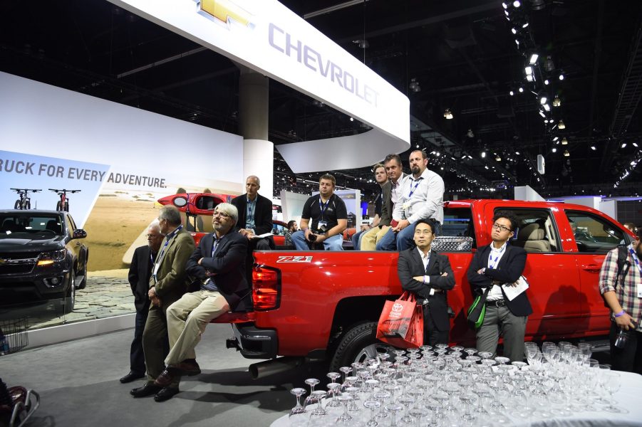 Attendees sit in the bed of a 2015 Silverado 2500 HD as they listen to the Chevrolet press conference, at the Los Angeles Auto Show