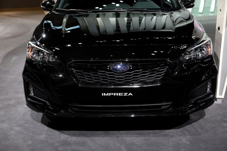 A black Subaru Impreza on display at an auto show