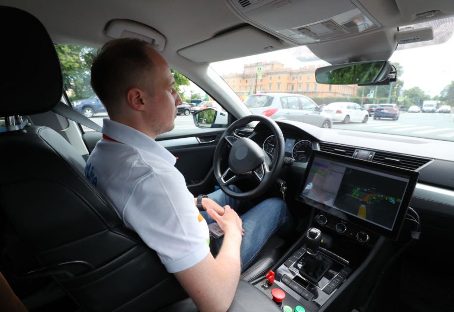 A driver sits behind the wheel of an autonomous car