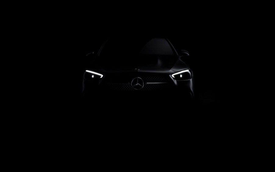 The headlights of a 2022 Mercedes-Benz C-Class peaking through the darkness