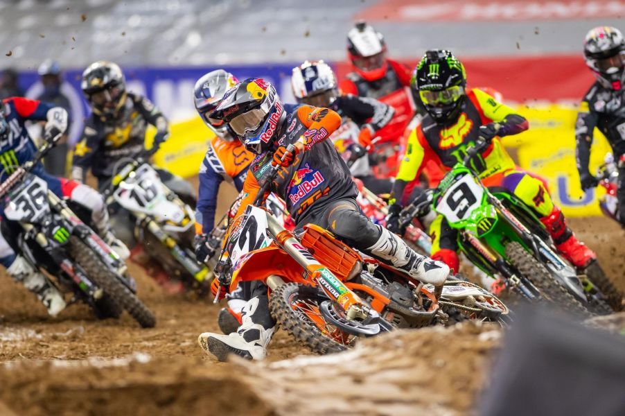 supercross riders competing for the hole shot as they turn around the first corner.