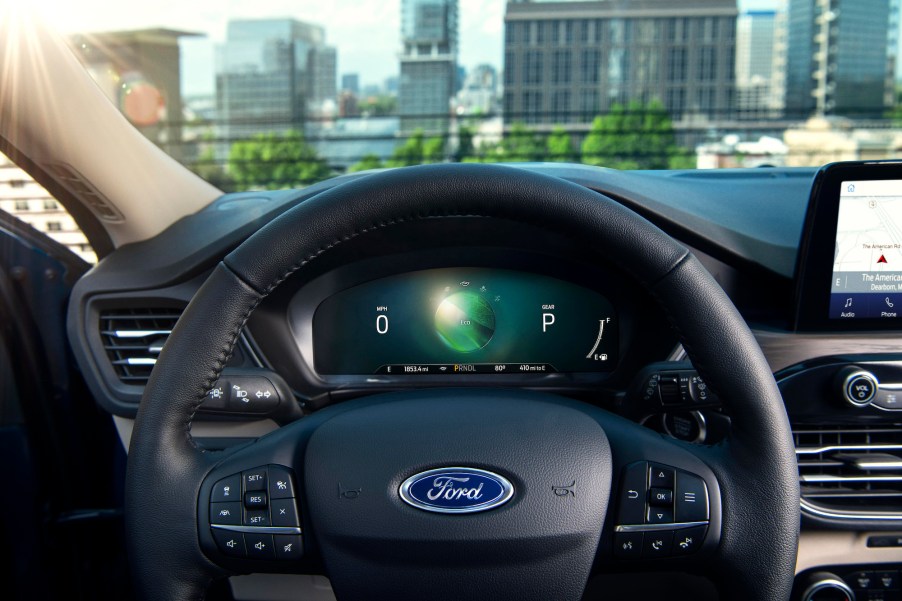 The black steering wheel and instrumentation panel of a 2020 Ford Escape Hybrid compact crossover SUV