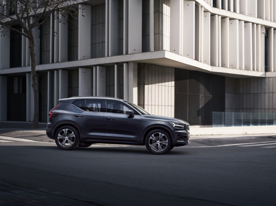 A 2020 Volvo XC40 compact luxury SUV with Denim Blue metallic exterior paint turning a corner next to a modern office building