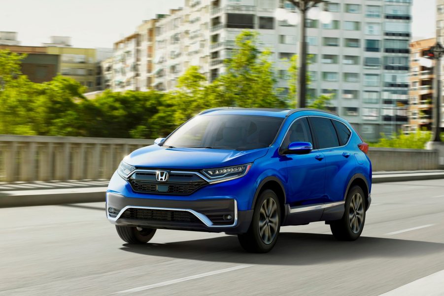 A blue 2021 Honda CR-V Touring driving down a highway road