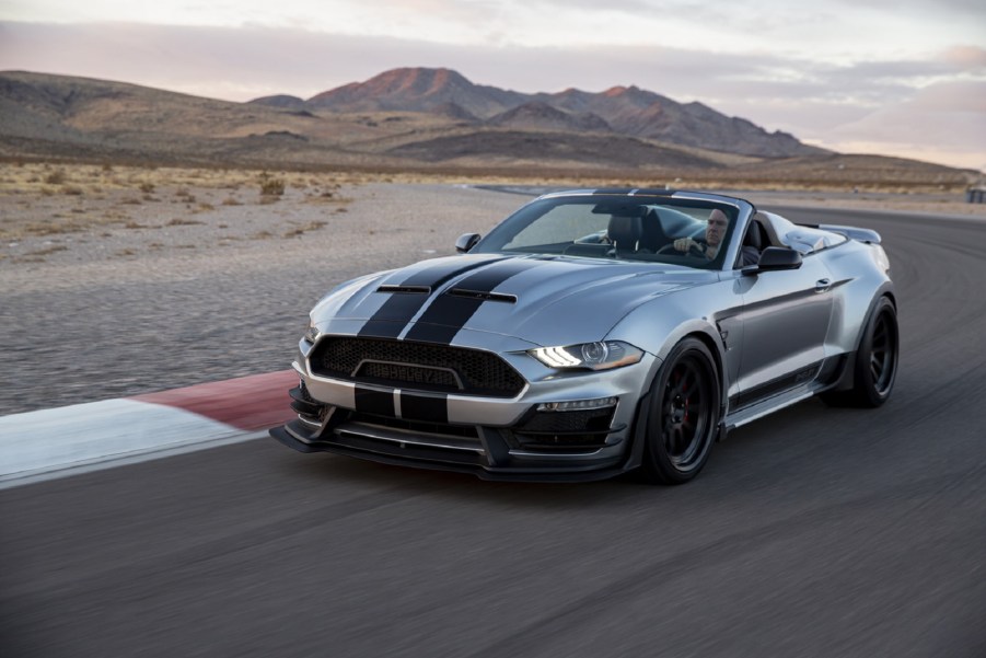 A silver-with-black-stripes 2021 Shelby Super Snake Speedster drives on a desert racetrack