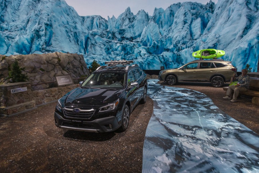 Some Subaru Outbacks traverse snowy terrain at an auto show