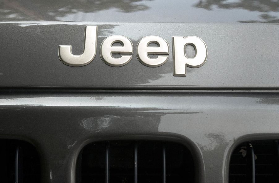 Closeup of the Jeep logo across the bumper of a gray Jeep Cherokee