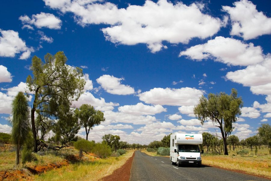 A white RV driving through the Australian countryside