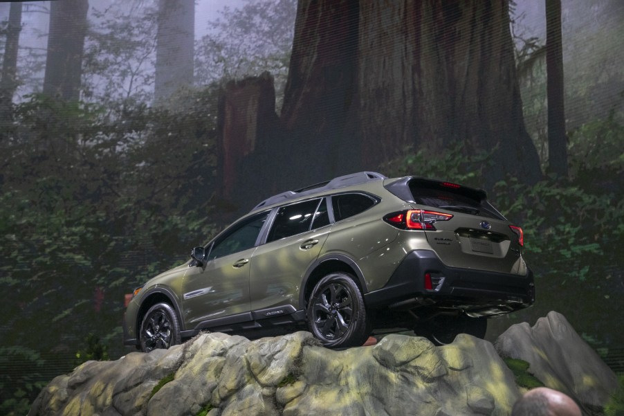 A Subaru Outback traverses a rock at a car show in 2020