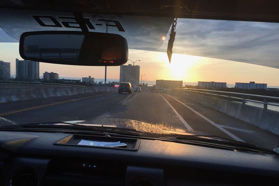 Overlooking a ford f-150 dash while going over a bridge at sunrise