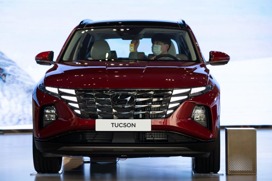 A customer wearing a protective mask sits inside a red Hyundai SUV – the Hyundai Tucson – on display at the company's Motorstudio showroom in Goyang, South Korea