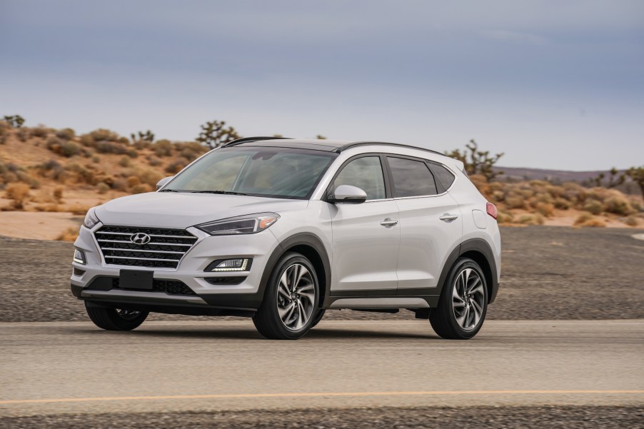 A shite 2021 Hyundai Tucson compact SUV parked on a two-lane road in a desert