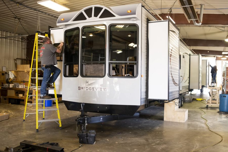 Workers assemble the exterior finish of a destination recreational vehicle (RV) at the HL Enterprise manufacturing facility in Elkhart, Indiana, U.S.