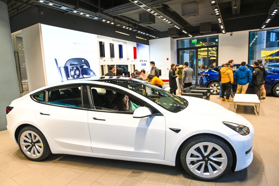 A white Tesla Model 3 vehicle is seen at a Tesla flagship store