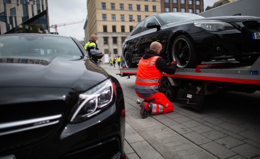 a man perpares a car for towing which a new study shows there are little state by state regulations in place to protect people from an unlawful tow