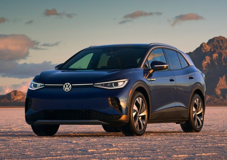 A blue 2021 Volkswagen ID.4 on a dusty lakebed by some desert mountains