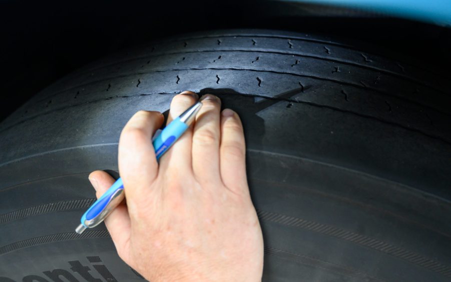 A man checks the tread on tires