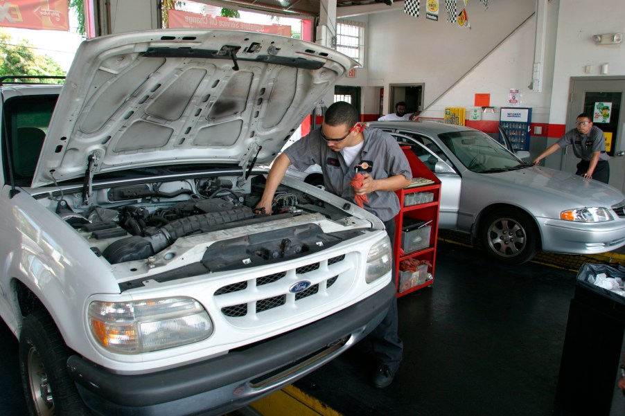 mechanic performs car maintenance on a Ford Explorer