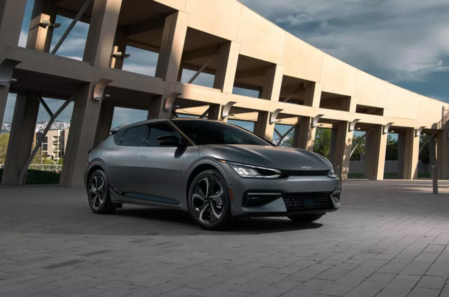 A dark colored 2022 Kia EV6 parked in front of a city building