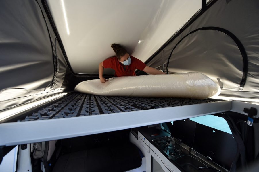 A worker installs the bed in the retractable tent on the roof of a Renault "Trafic" van converted into a motorhome, in the factory of the Pilote group, in Longuenee-en-Anjou, western France