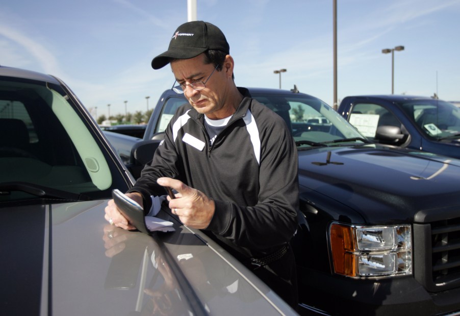 Car salesman Pete Argumaniz checks the VIN on a used car at Classic Buick-Pontiac-GMC in Arlington, Texas, on December 12, 2008